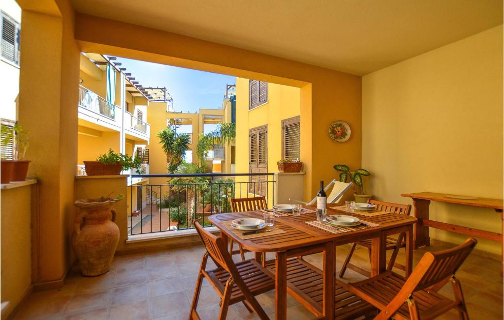 een eetkamer met een tafel en stoelen en een balkon bij Appartamento Clizia 2 in Marinella di Selinunte