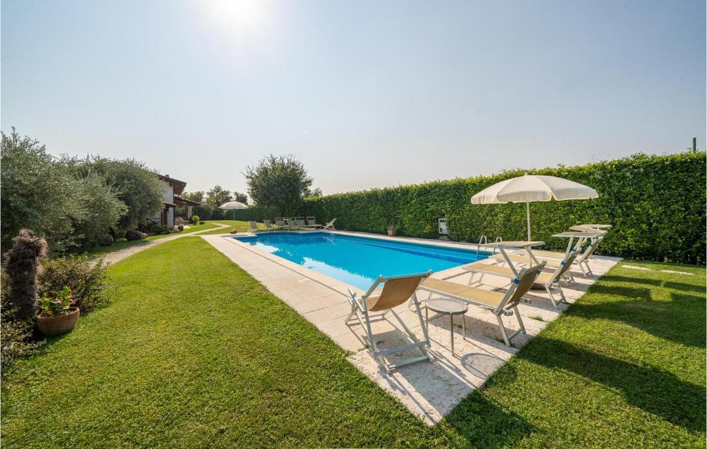 a swimming pool with a table and an umbrella at Macchia Rossa in Caprino Veronese