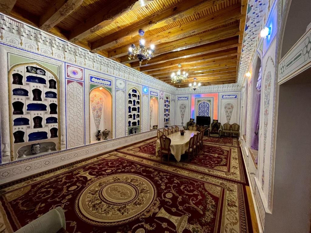 Habitación grande con una mesa en el medio. en Shukrona Guest house, en Bukhara