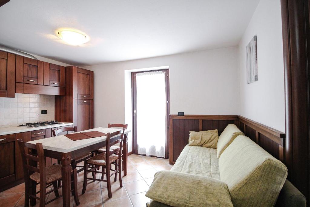 un soggiorno con divano e tavolo e una cucina di Residence Aquila - Bilo Punta Goà a Brusson