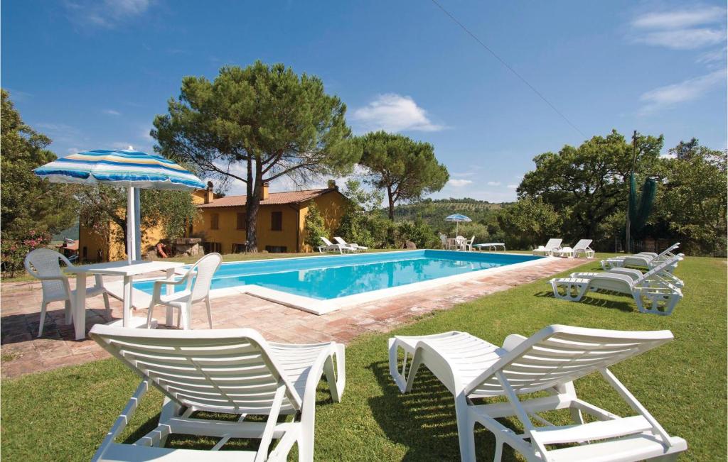 een groep stoelen en een parasol naast een zwembad bij Casa Cantina in Magione