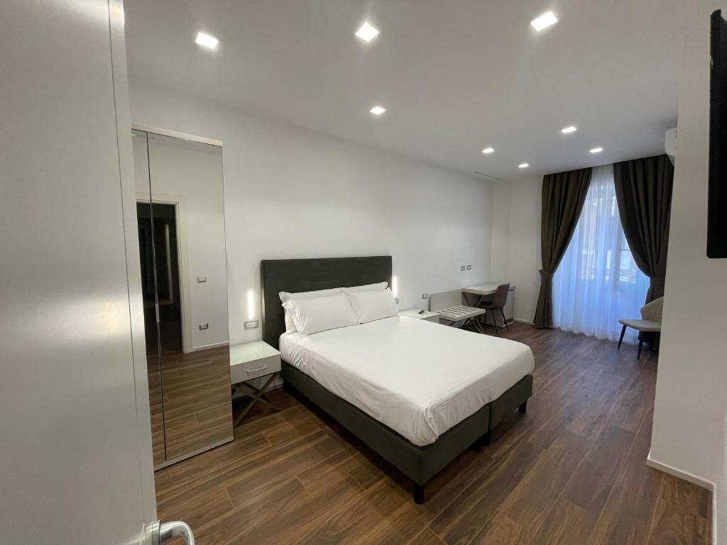 - une chambre avec un lit blanc et un miroir dans l'établissement AngelicaHome Roma, à Rome