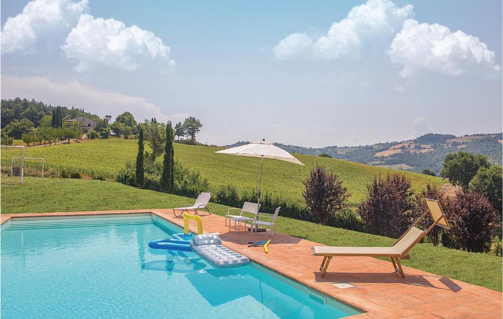 a swimming pool with chairs and an umbrella at Podere Case Sparse in Citerna