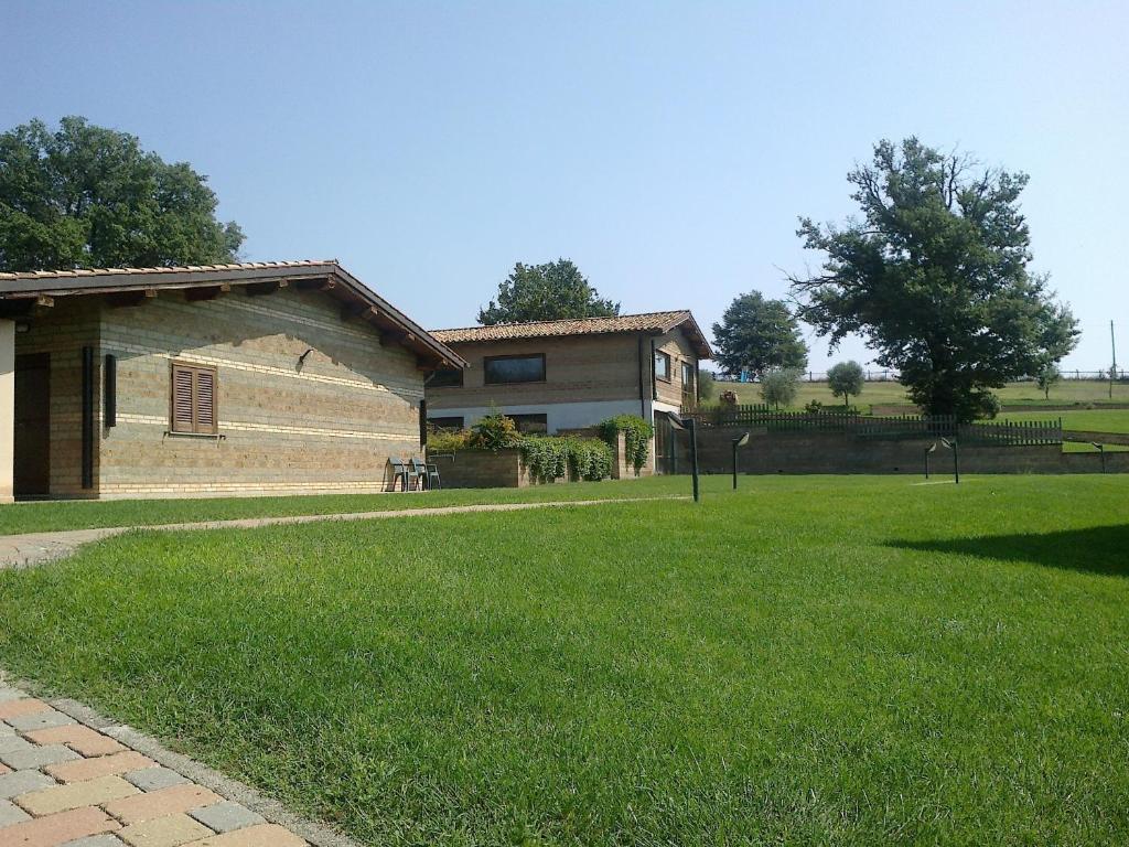ein Haus mit einem Rasenplatz neben einem Gebäude in der Unterkunft Agriturismo Monte dell'Olmo in Trevignano Romano