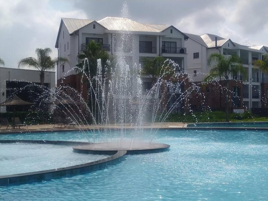 a fountain in the water in front of a building at Breathtaking Lagoon View Apartment @ The Blyde1531 in Pretoria