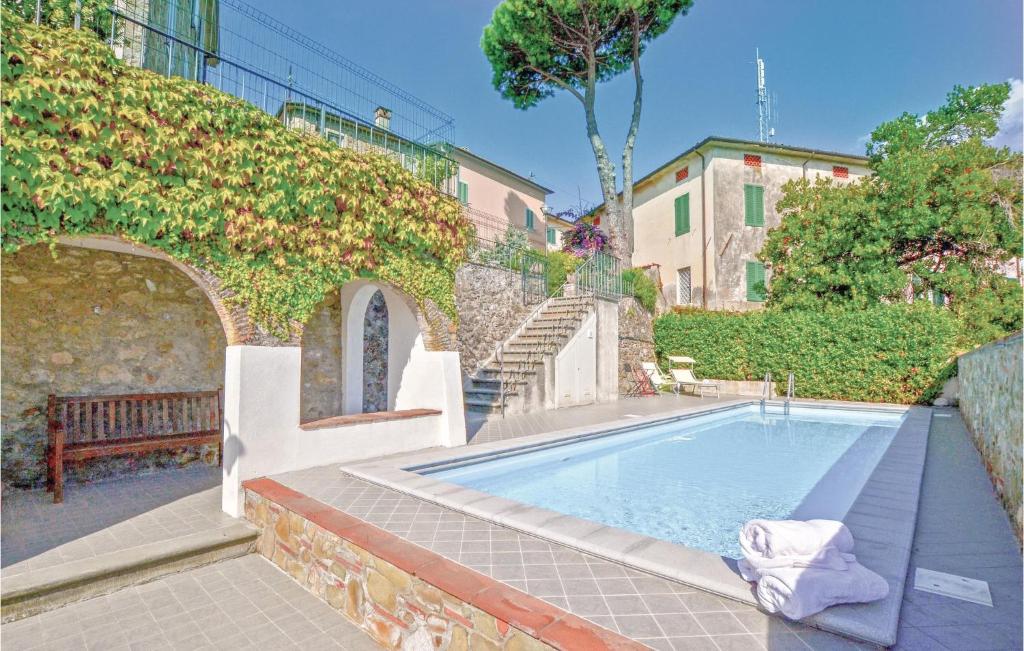 a swimming pool with a bench next to a building at Riccio in Piano di Mommio