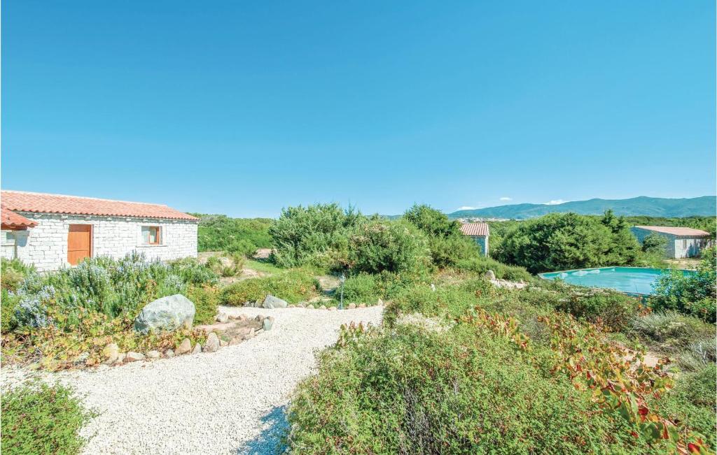 einen Weg, der zu einem Haus und einem Pool führt in der Unterkunft Mare Dei Ginepri Bilocale in Badesi