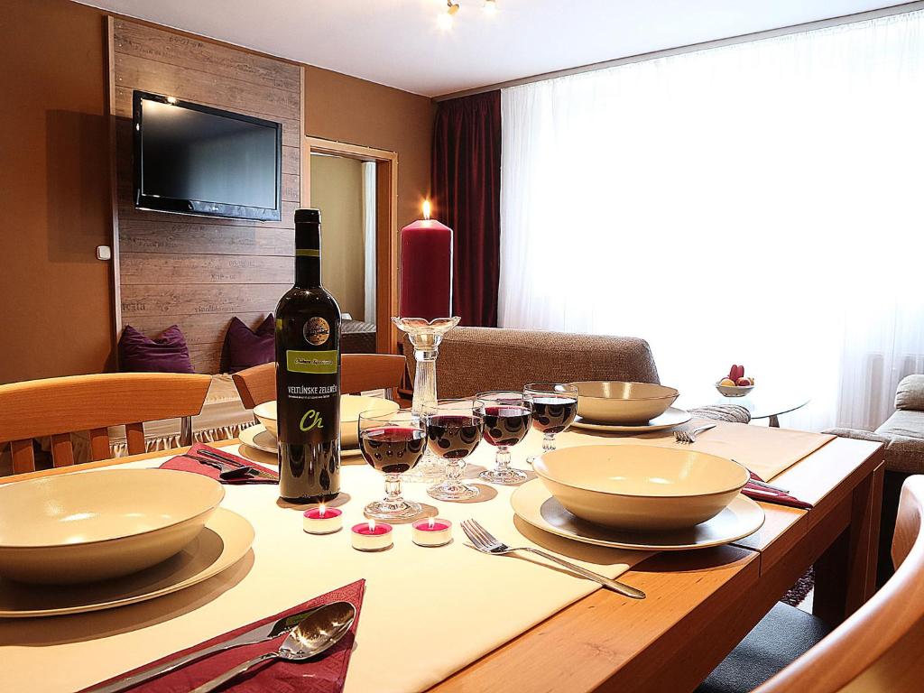 a table with a bottle of wine and glasses on it at Apartments City Centre in Bratislava