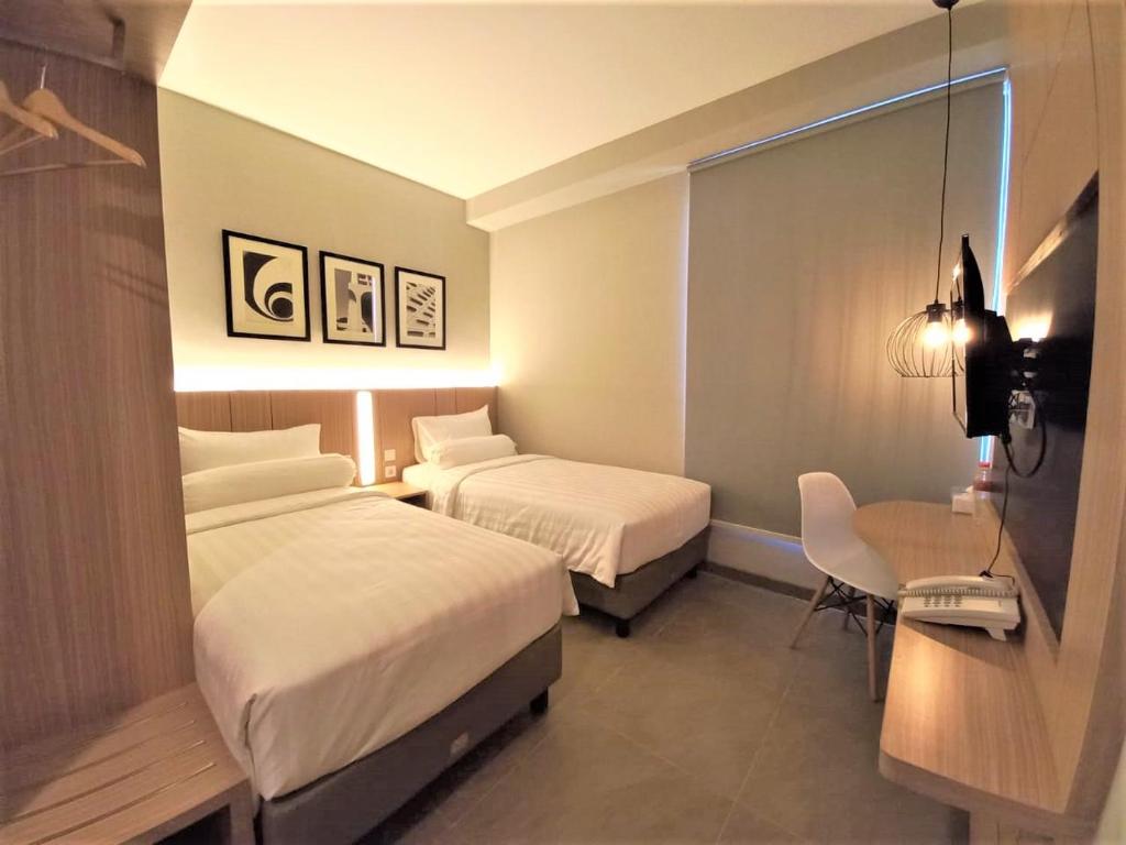 Postel nebo postele na pokoji v ubytování Front One King Hotel Tuban