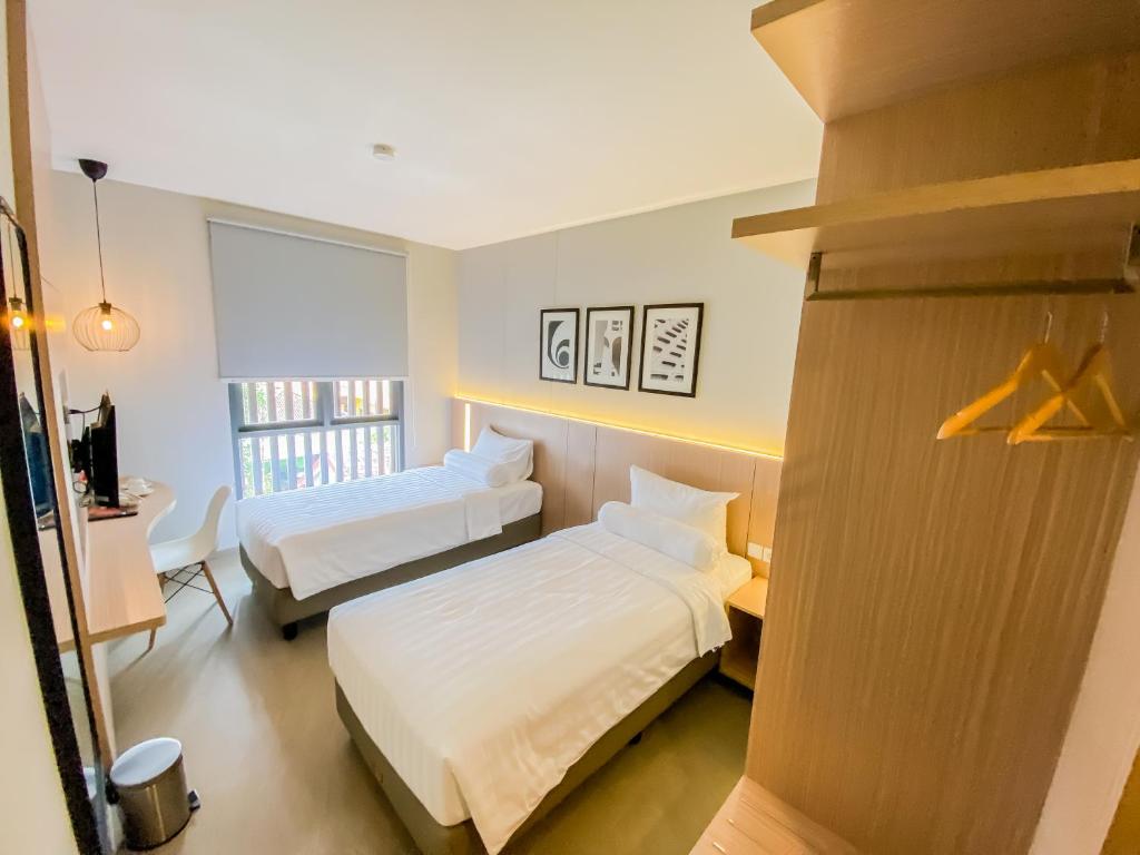 um quarto de hotel com duas camas e uma secretária em Front One King Hotel Tuban em Tuban