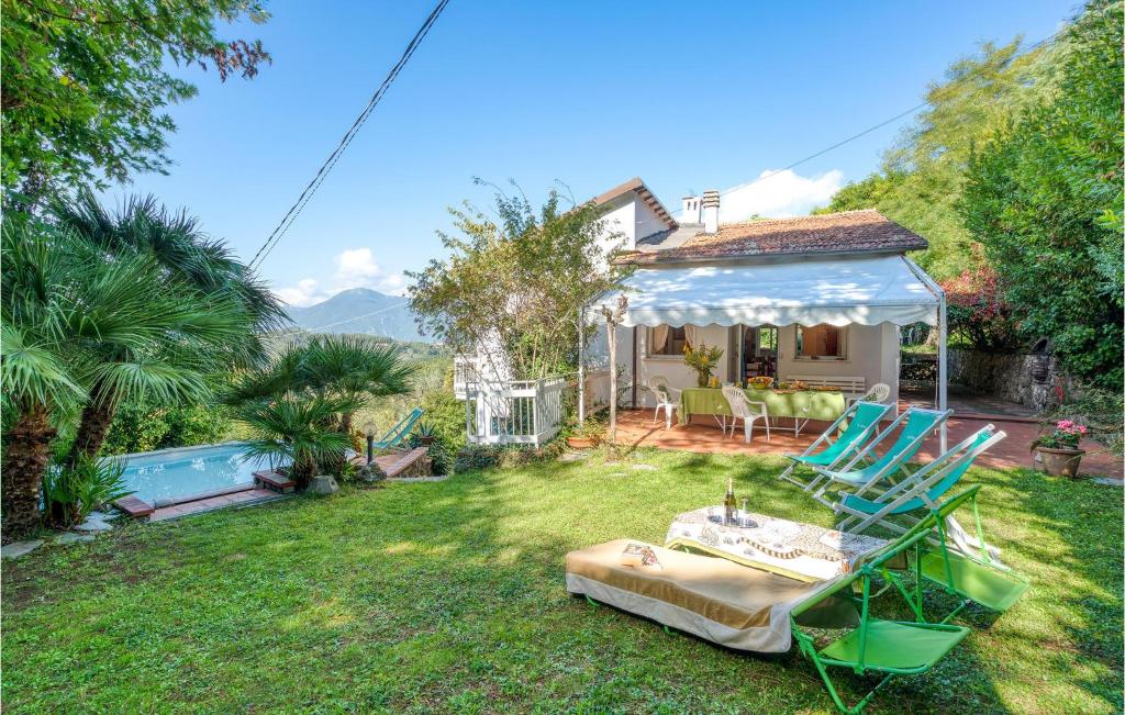 a garden with chairs and a table and a house at I Tre Olivi in Valpromaro
