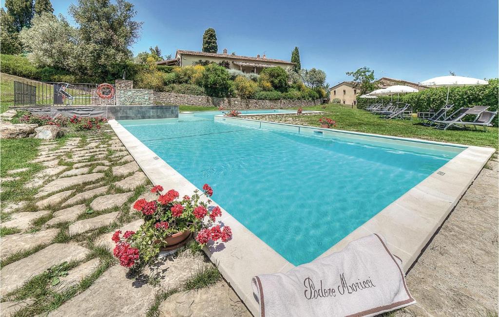a swimming pool with flowers in a yard at Scipione - Podere Moricci in Montaione
