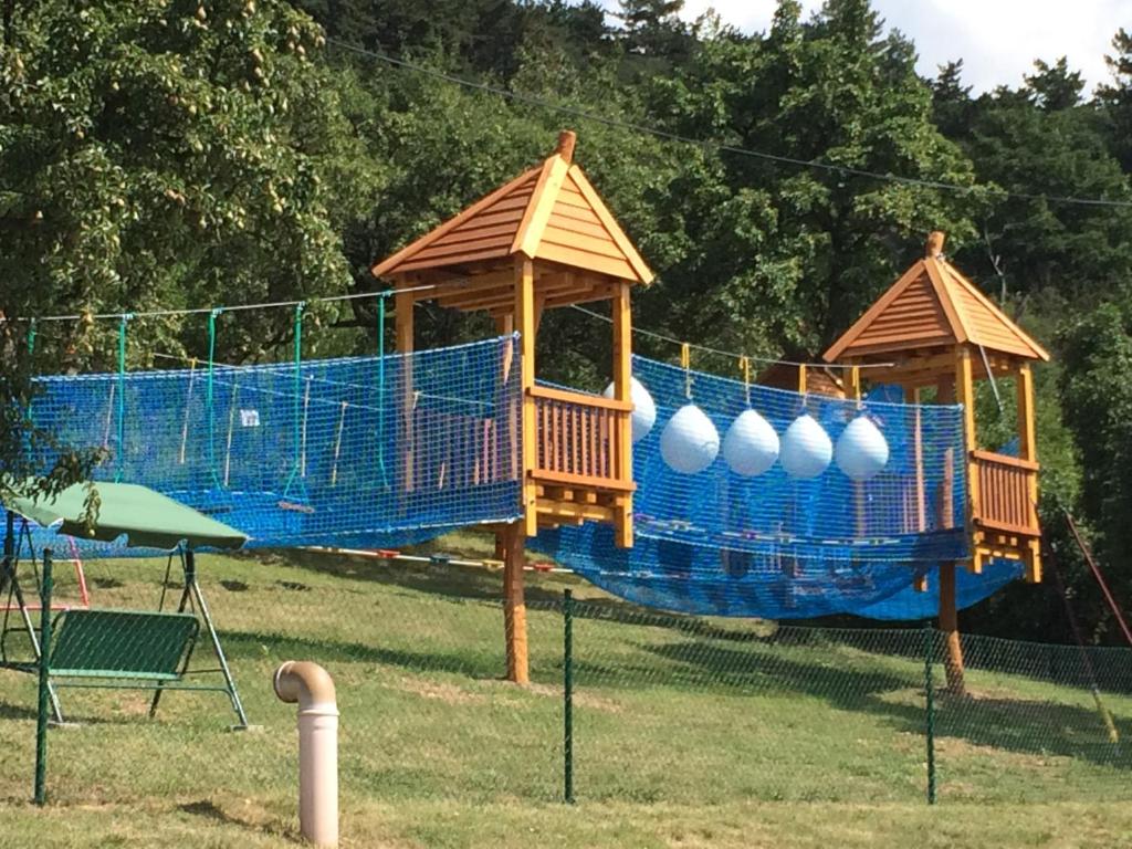 een speeltuin met twee tuinhuisjes en een schommel bij Hotel Pohádka in Most