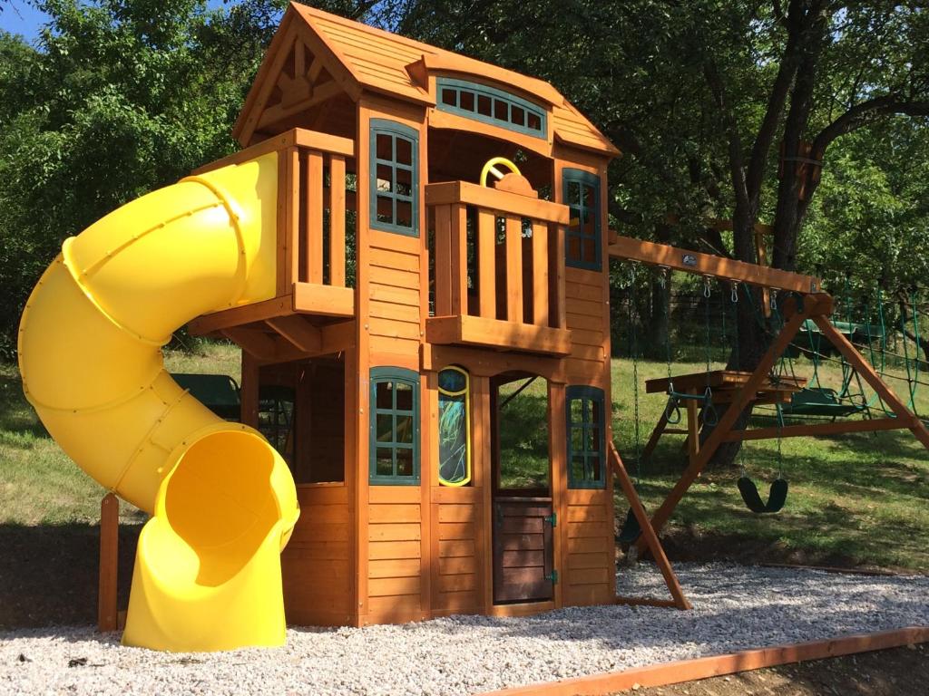een klein houten speelhuis met een glijbaan bij Hotel Pohádka in Most
