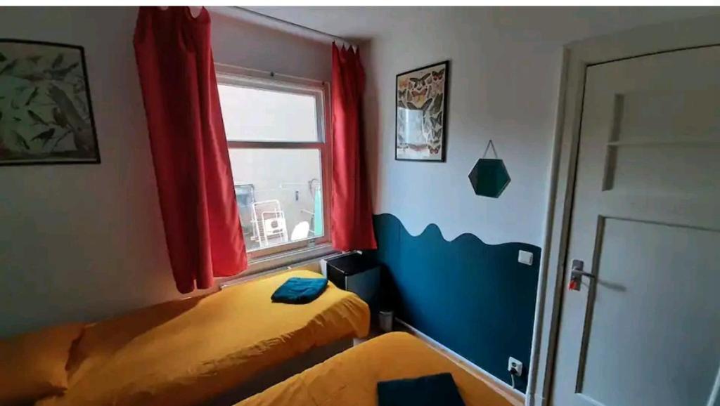 Habitación pequeña con 2 camas y ventana en Room Nicole, not for parties, not a hotel en Ámsterdam