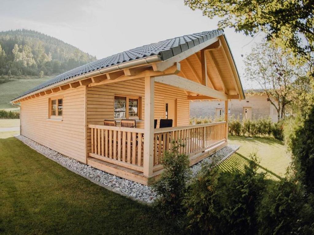 a large wooden cabin with a large deck at Natur-Camp Tannenfels in Baiersbronn