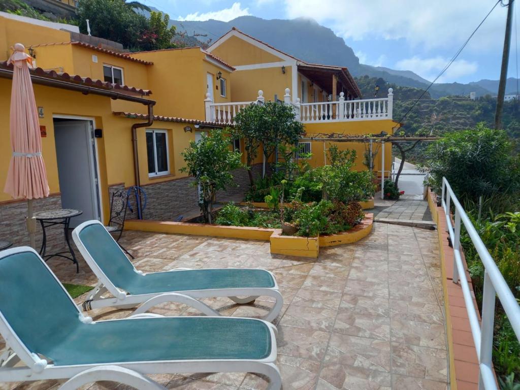 a patio with two chairs and a house at Orange House in Vallehermoso