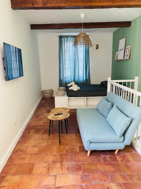 - un salon avec un canapé bleu et un lit dans l'établissement La Dolce Vita, à Carcassonne