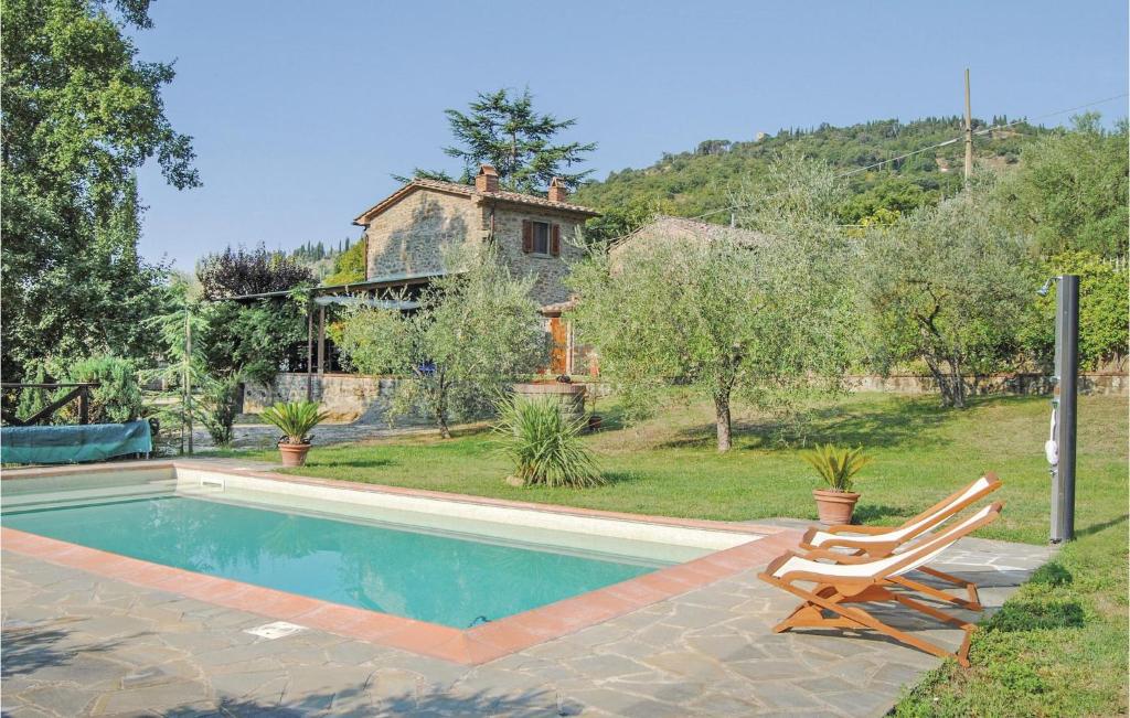 einen Pool mit einem Stuhl und ein Haus in der Unterkunft La Torretta in Cortona