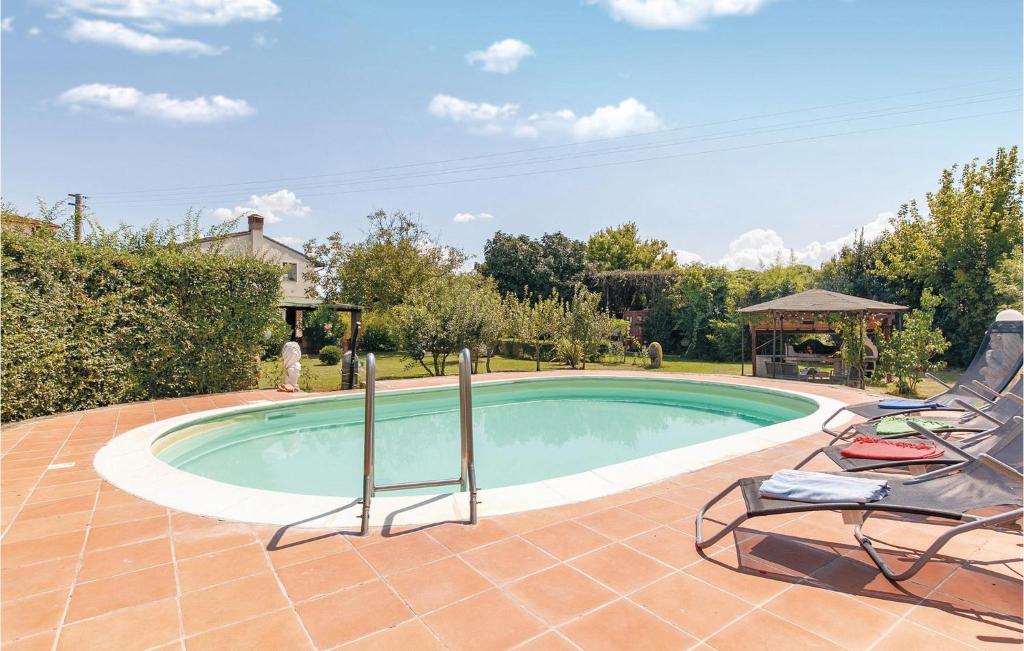 a swimming pool with two chairs and a gazebo at Il Kiwi in San Giovanni Alla Vena