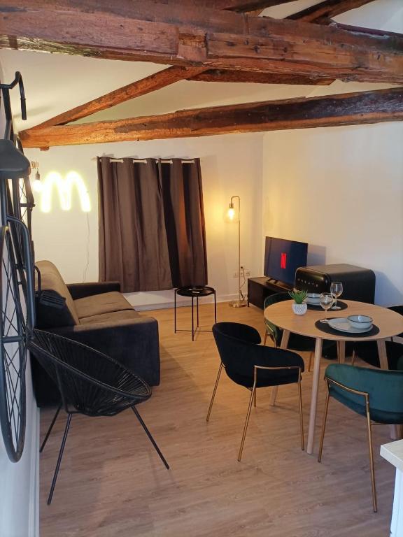 un salon avec un canapé, une table et des chaises dans l'établissement L’UNDERGROUND Studio Hyper-Centre, à Carcassonne