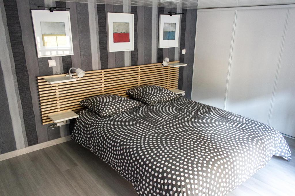 um quarto com uma cama preta e branca com 2 almofadas em La Voluptine em Reims