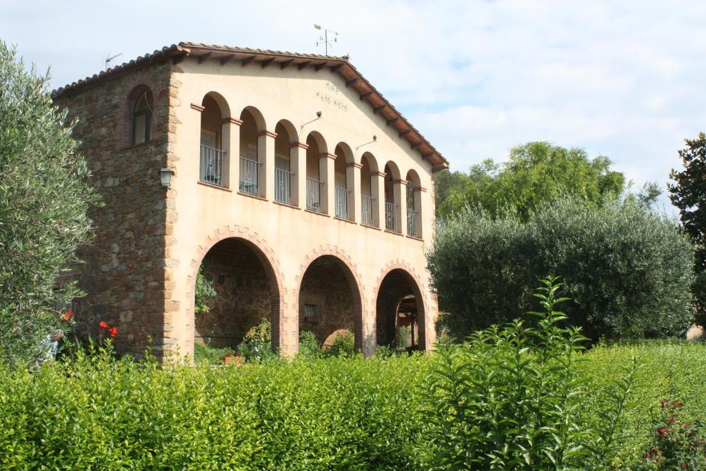 un antiguo edificio de ladrillo con ventanas en un campo en Mas Puig Roig, en Llaviá