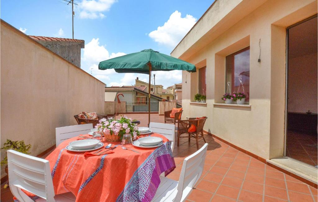 een tafel met een groene parasol op een patio bij Casa Vacanze Belice in Santa Margherita di Belice