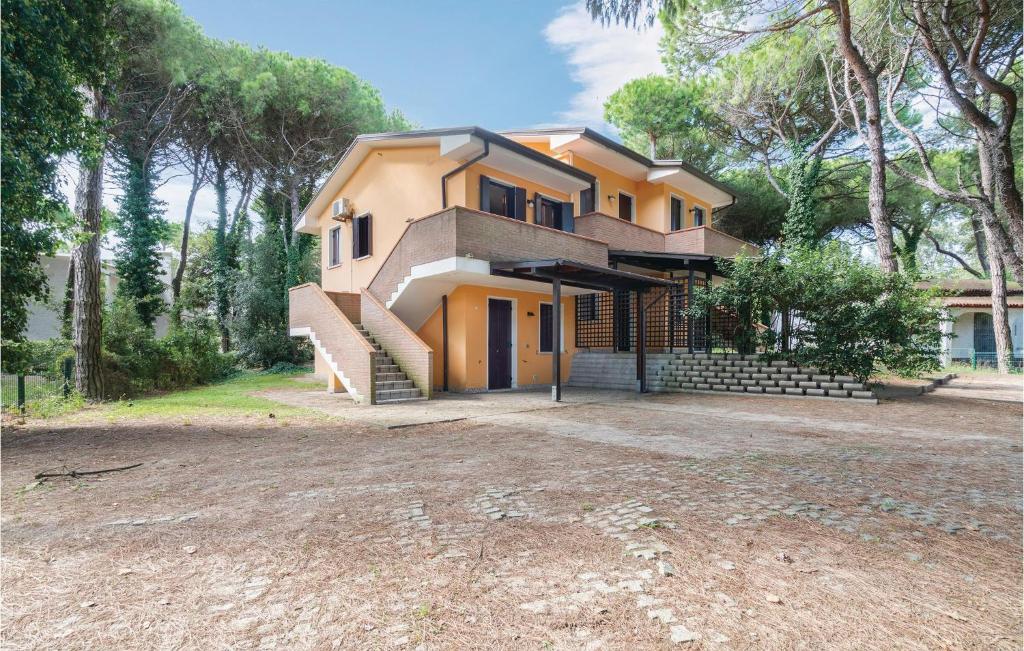 a yellow house with a staircase in front of it at Lovely Apartment In Rosolina Mare in Rosolina Mare