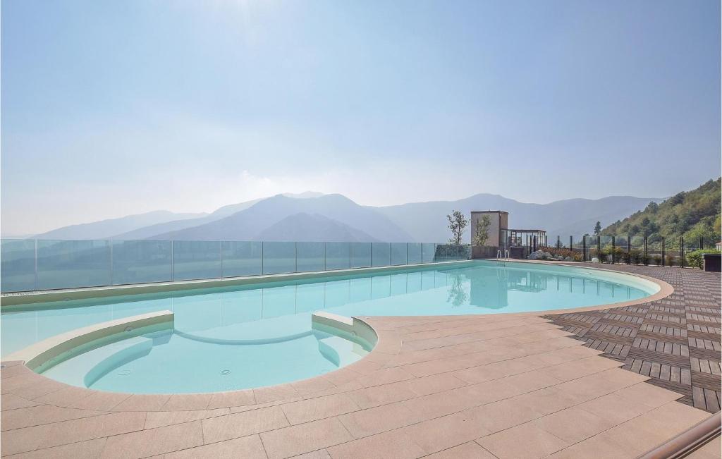 a large swimming pool with mountains in the background at Beautiful Home In Magliolo With 2 Bedrooms And Outdoor Swimming Pool in Magliolo