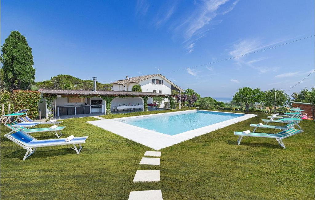 a swimming pool with lounge chairs and a house at Villa James in San Costanzo