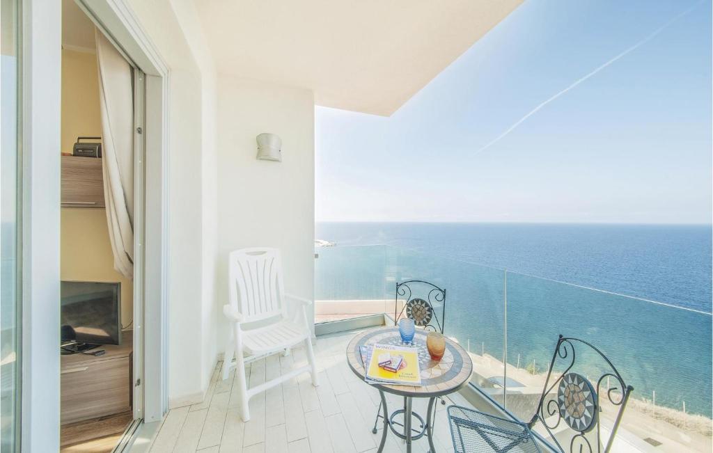 balcón con mesa, sillas y vistas al océano en Miramare en Castelsardo
