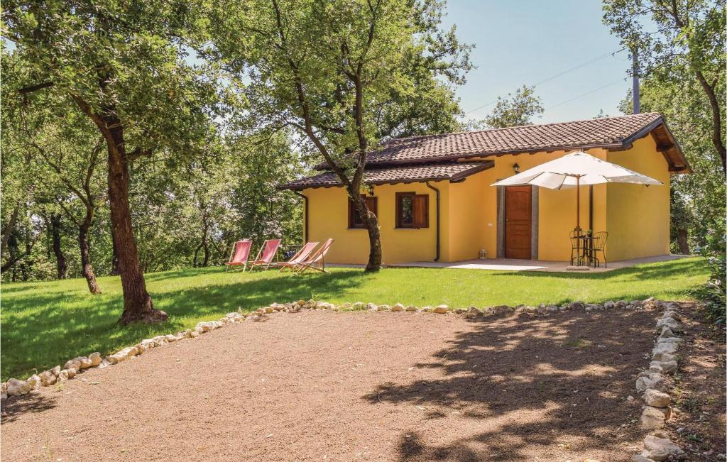 法布里卡－迪羅馬的住宿－2 Bedroom Beautiful Home In Fabrica Di Roma -lt-，一座带庭院和遮阳伞的黄色小房子