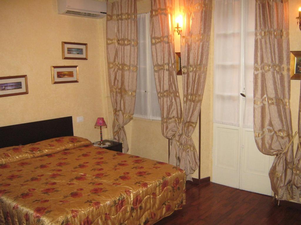 1 dormitorio con 1 cama y una ventana con cortinas en Residenza Tre Marchetti, en Verona