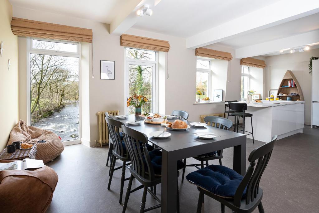 a kitchen and dining room with a table and chairs at Mint Mill: New riverside apartment in historic mill in Kendal
