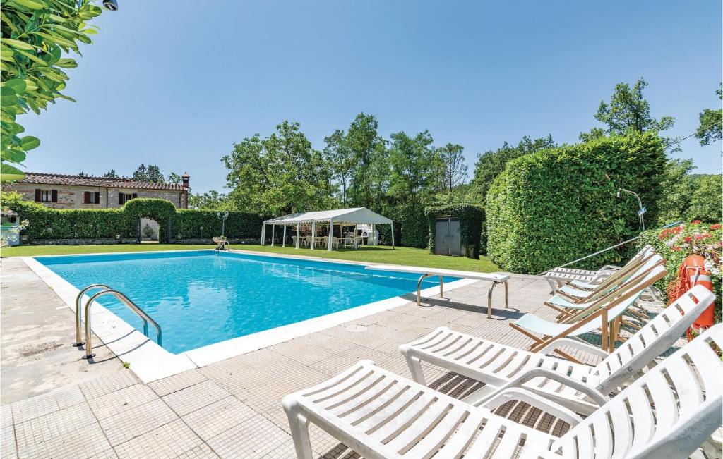 a swimming pool with white lounge chairs next to it at Casa Terrossoli in Capolona