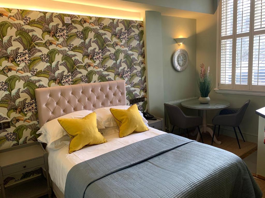 una camera da letto con un grande letto con cuscini gialli di Vancouver Studios a Londra