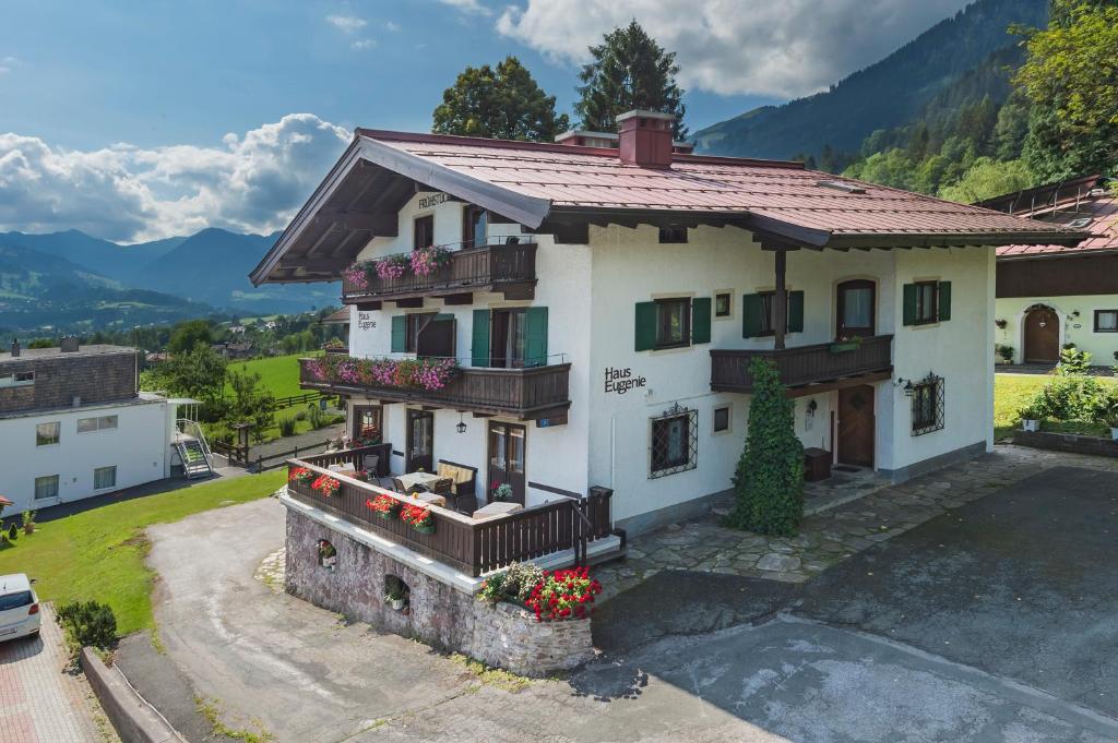 uma casa nas montanhas com uma varanda em Frühstückspension & Appartements Eugenie em Kitzbühel