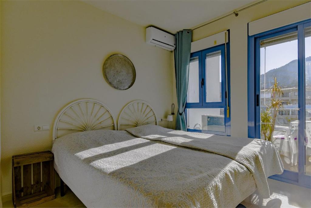 een slaapkamer met een bed en een groot raam bij south facing 2 bedroom apartment in centre Albir in Albir