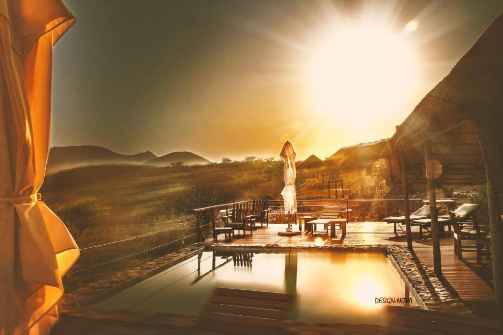 a view of a pool with tables and a sun at Kapika Waterfall Lodge in Epupa