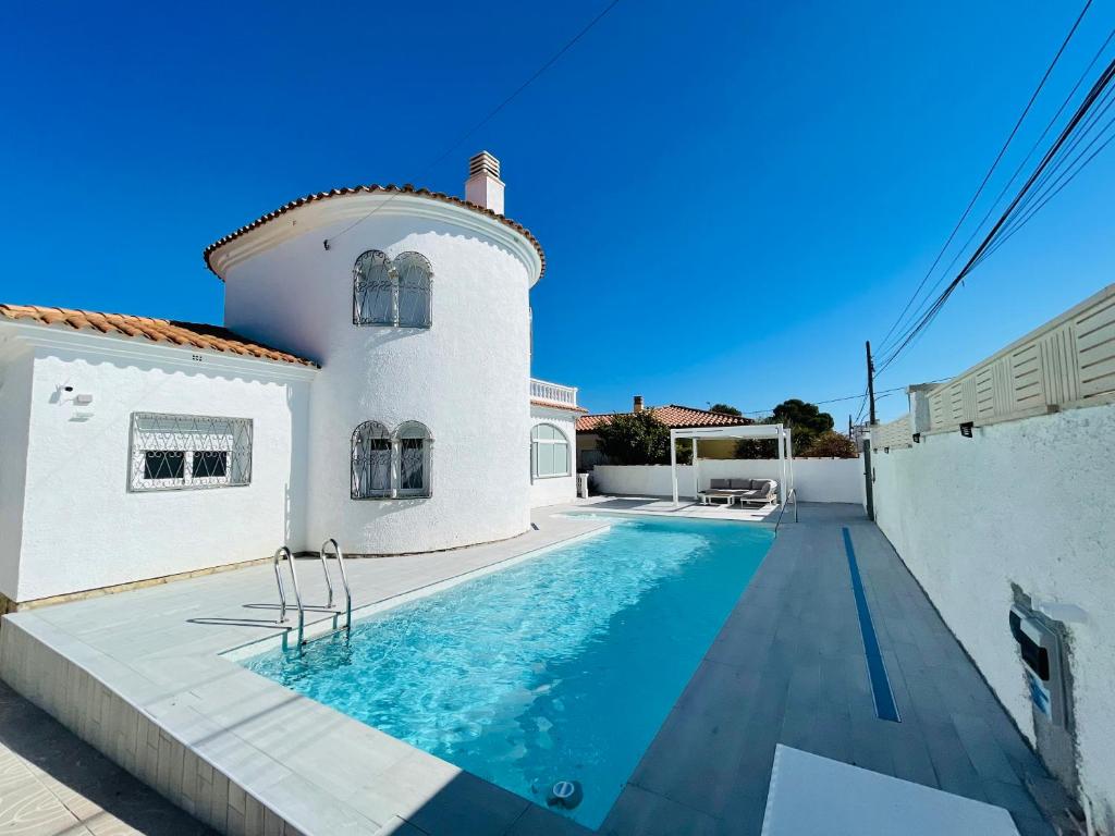a villa with a swimming pool in front of a house at Villa “Castellón“ in Miami Platja