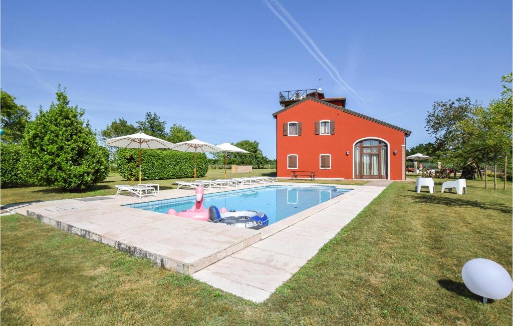 una piscina di fronte a una casa rossa di Porta Di Valle 1 a Cavallino-Treporti