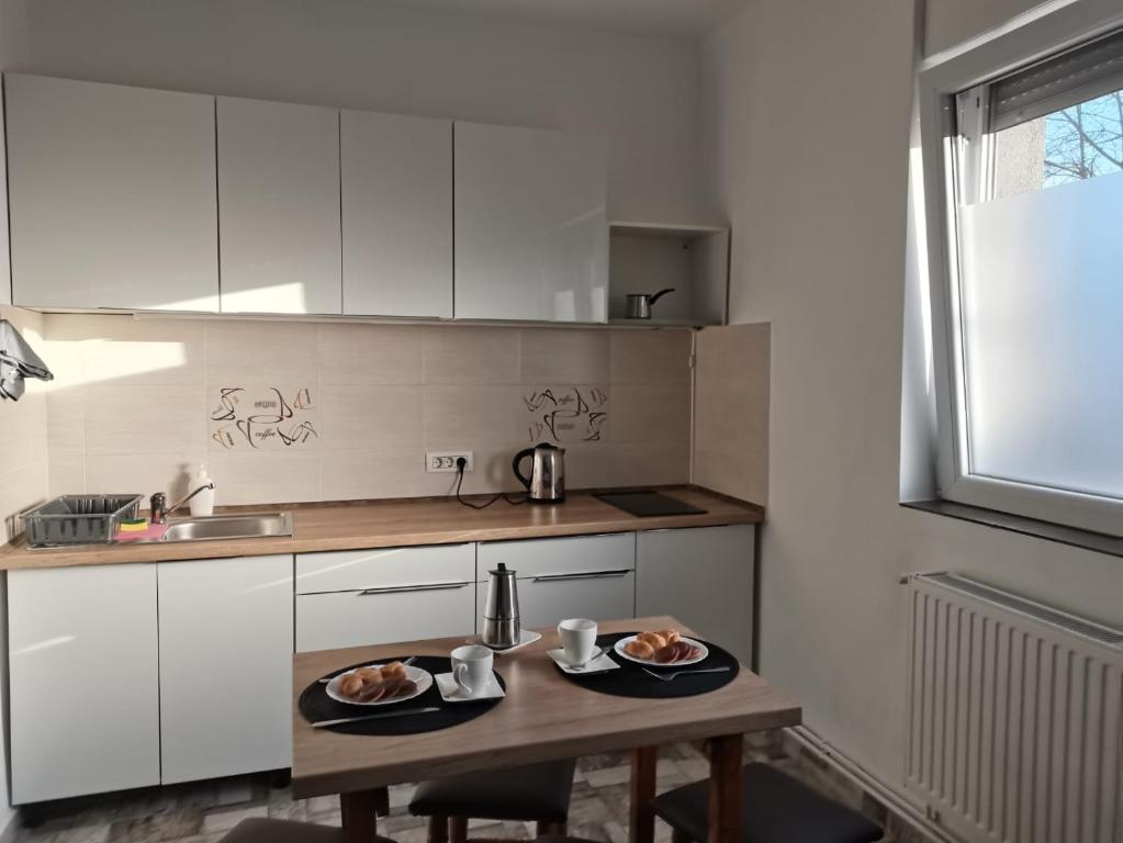 奥拉迪亚Carla's place Ap1的厨房里配有一张桌子,上面放着两盘食物