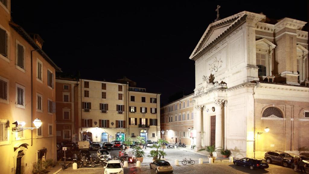 un edificio con una torre de reloj en una ciudad por la noche en Guesthouse Coronari Courtyard, en Roma