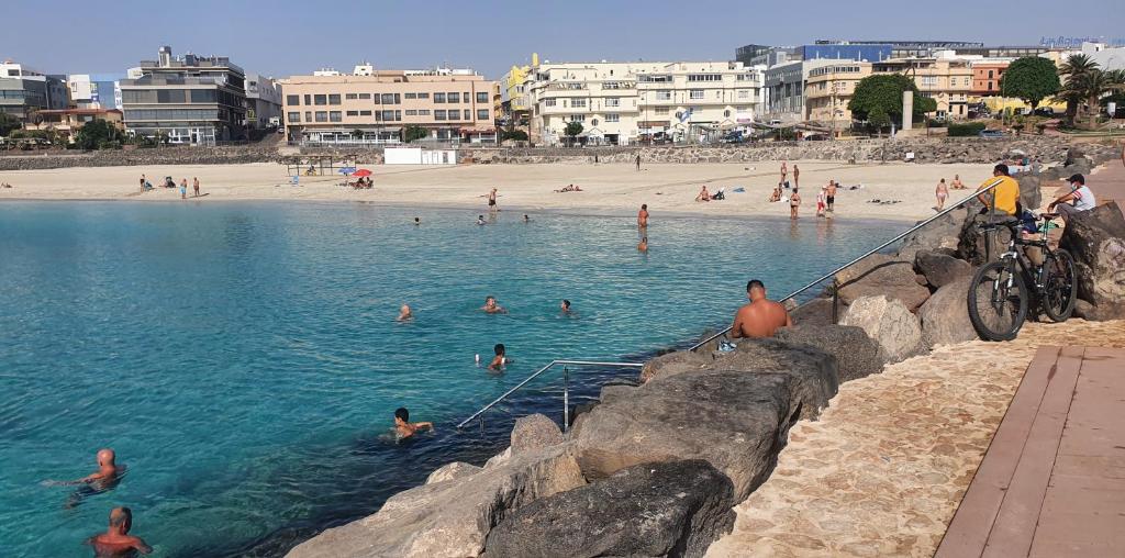 a group of people in the water at a beach at Casa maria in Puerto del Rosario