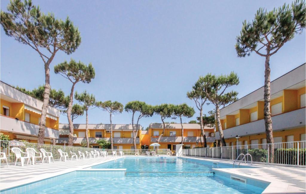 una piscina in un resort con sedie e alberi di La Piazzetta a Rosolina Mare