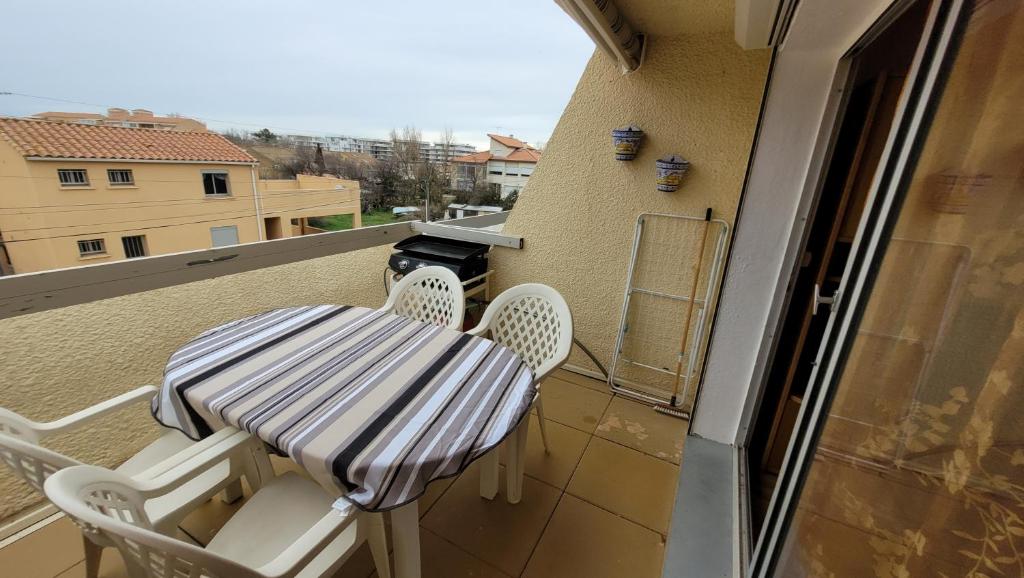 einen Balkon mit einem Tisch und Stühlen in der Unterkunft Hollywood E24 - T2 avec terrasse à 2 minutes de la plage in Valras-Plage