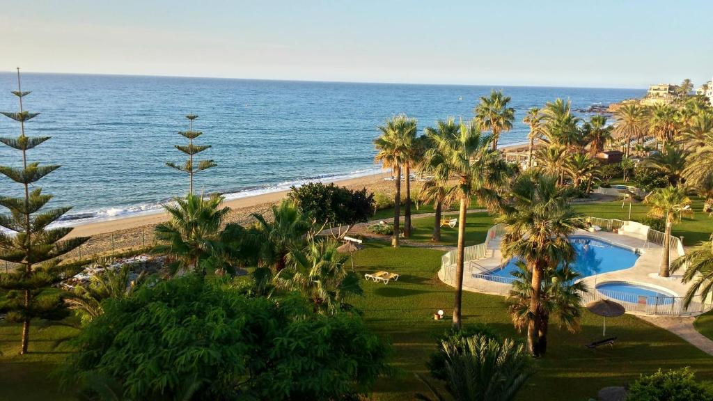 vista su una spiaggia con palme e piscina di Las Mimosas, La Cala de Mijas a La Cala de Mijas