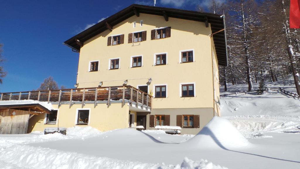 ein großes Gebäude im Schnee mit Schnee um ihn herum in der Unterkunft Skihütte Zams in Zams