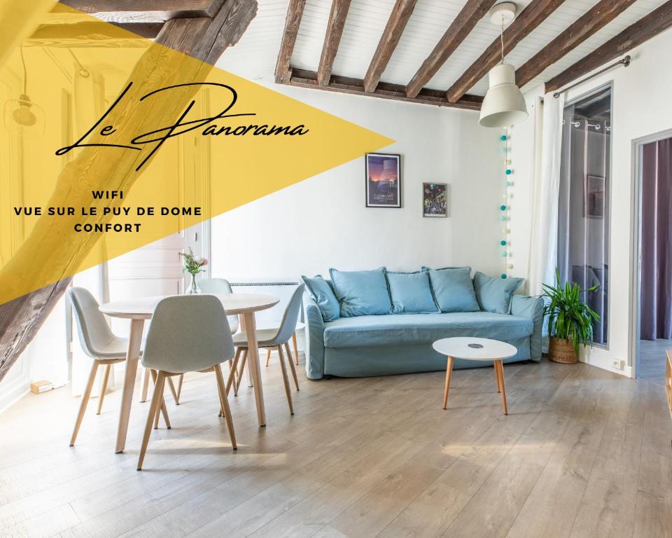 un salon avec un canapé bleu et une table dans l'établissement Le Panorama, à Clermont-Ferrand